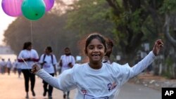 A girl runs carrying balloons during a marathon ahead of the International Women’s Day in Hyderabad, India, March 6, 2023.