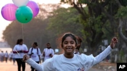 Djevojčica trči noseći balone tokom maratona pred Međunarodni dan žena u Hajderabadu, Indija, 6. mart 2023.