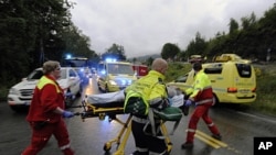 Rescue personnel push an injured victim away from the camp site in Utoeya, Norway, July 23, 2011