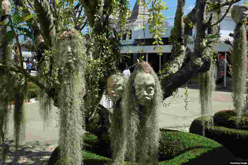 Những chậu đựng cây hình mặt người treo trên cây tại Wat Rong Khun, một ngôi chùa Phật giáo đương đại và độc đáo ở tỉnh Chiang Rai, Thái Lan, được thiết kế vào năm 1997 bởi nghệ sĩ Thái Chalermchai Kositpipat. (Ảnh của độc giả Matthew Richards/Thái Lan, ngày 26 tháng 10, 2014)