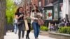 FILE - Pedestrians walk along Boston's fashionable Newbury Street, May 2, 2021. The CDC said Thursday that fully vaccinated people can safely stop wearing masks in most indoor and outdoor settings.