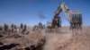 Afghans dig a trench for a common grave for their relatives killed in an earthquake to a burial site in Zenda Jan district in Herat province, western of Afghanistan, Oct. 9, 2023. 