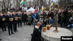 Ukrayna Prezidenti Petro Poroşenko və xanımı Marina Holodomor qurbanlarına ucaldılmış abidə önündə baş əyirlər. Kyiv, Ukrayna. 22 noyabr, 2014.