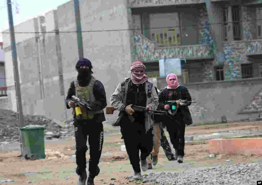 Gunmen patrol the streets during clashes with Iraqi security forces in Fallujah, Jan. 5, 2014.