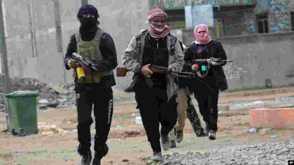 Gunmen patrol the streets during clashes with Iraqi security forces in Fallujah, Jan. 5, 2014.