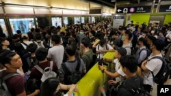 Para penumpang harus antri saat demonstran pro-demokrasi Hong Kong turun ke stasiun kereta bawah tanah, Selasa pagi (30/7). 