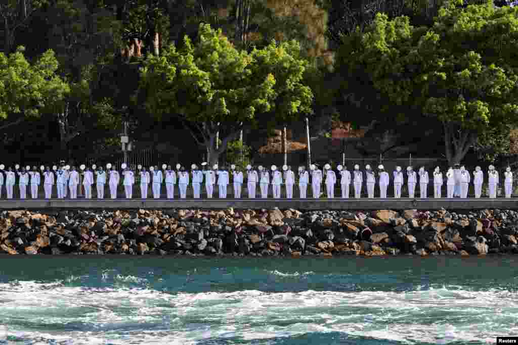 Crew members salute on the day Britain&#39;s King Charles and Queen Camilla carry out an Australian Navy fleet review in Sydney Harbour during a visit to Sydney.