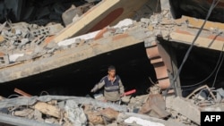 A youth salvages items from the rubble of a building destroyed in Israeli strikes in Deir el-Balah in the central Gaza Strip on Nov. 5, 2024.