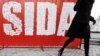 A girl walks past a banner reading SIDA (AIDS) created using condom packets, during an HIV/AIDS awareness event staged by the Red Cross in Bucharest, Romania, Tuesday, Dec. 2, 2008. Romania has an estimated 15,000 people living with HIV. (AP Photo…