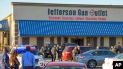 Bystanders react at the scene of a multiple-fatality shooting at the Jefferson Gun Outlet in Metairie, La., Feb. 20, 2021.