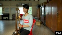 Om Daro, a freshman at the Royal University of Fine Arts, poses with his trombone during a rehearsal at Kolab Primary School in Phnom Penh on September 16, 2018. (Rithy Odom/VOA Khmer)
