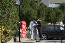 Forensic experts are seen at the site where Greek journalist George Karaivaz was fatally shot, in Athens, Greece, April 9, 2021.