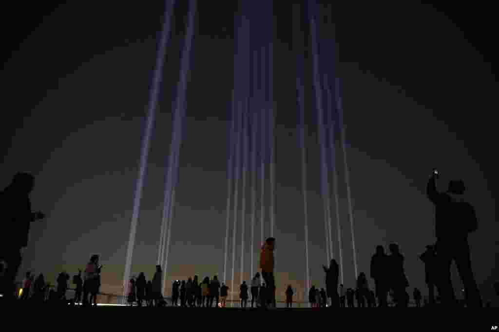 People take pictures of a light show called &quot;Crossing Light&quot; at Shibuya Sky observation deck in the Shibuya district of Tokyo, Japan.