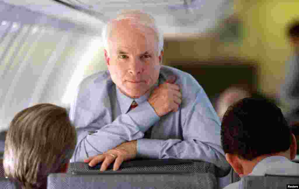 Arizona Senator and Republican presidental hopeful John McCain looks up while speaking with his campaign manager Rick Davis (L) and national political director John Weaver during a flight from South Carolina to California February 4.