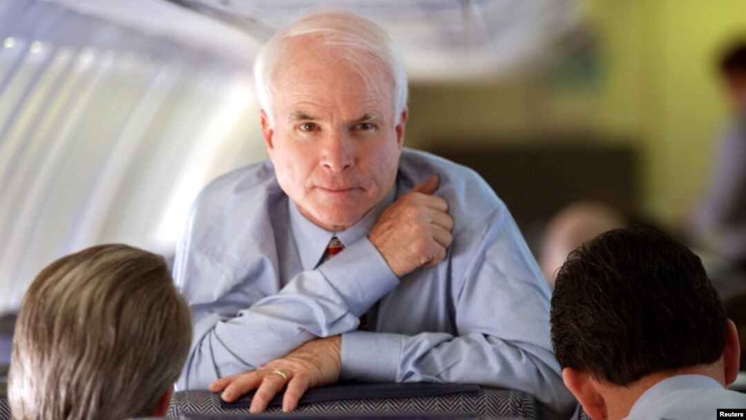 Arizona Senator and Republican presidential hopeful John McCain looks up while speaking with his campaign manager Rick Davis, left, and national political director John Weaver during a flight from South Carolina to California Feb. 4, 2000.