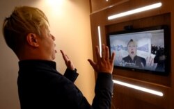 Associate professor ilmu komputer di University of Southern California Hao Li memamerkan video 'deepfake' dengan mantan Perdana Menteri Inggris Theresa May selama pertemuan tahunan Forum Ekonomi Dunia (WEF) ke-50 di Davos, Swiss, 22 Januari 2020. (Foto: R