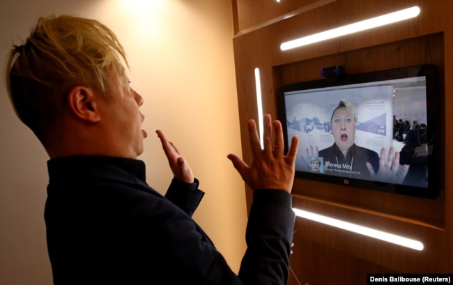 Associate professor ilmu komputer di University of Southern California Hao Li memamerkan video 'deepfake' dengan mantan Perdana Menteri Inggris Theresa May selama pertemuan tahunan Forum Ekonomi Dunia (WEF) ke-50 di Davos, Swiss, 22 Januari 2020. (Foto: R