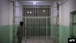 FILE - A member of the Syrian Democratic Forces (SDF) stands guard in a prison in the city of Hasakeh, Syria, Oct. 26, 2019.