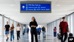 Lindsay Ruck, a server at Phoenix Sky Harbor International Airport restaurants, pauses in Terminal 3 as she is anticipates the vote on Arizona Prop 138 on minimum wage, Oct. 3, 2024, in Phoenix.