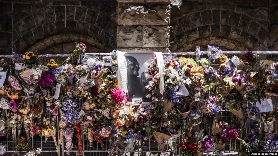 Bouquets hang next to a portrait of South African anti-apartheid icon Archbishop Desmond Tutu at the wall of remembrance outside St. George's Cathedral in Cape Town, Dec. 31, 2021.