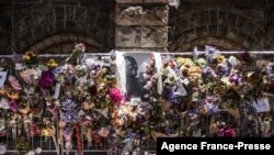 Bouquets hang next to a portrait of South African anti-apartheid icon Archbishop Desmond Tutu at the wall of remembrance outside St. George's Cathedral in Cape Town, Dec. 31, 2021.