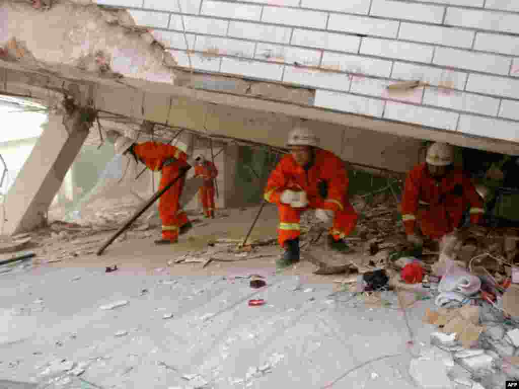 Rescuers search for survivors from the ruins of a damaged building after an earthquake hit Yingjiang county, Yunnan province March 11, 2011. The 5.8-magnitude earthquake has left at least 25 people dead and 250 others injured, Xinhua News Agency reported.