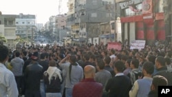 Protesters gather during a demonstration in the Syrian port city of Banias, as forces deployed around the small coastal city for a possible attack, a rights campaigner in contact with Banias said, April 26, 2011