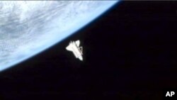 In a frame grab made from NASA TV, space shuttle Discovery leaves the International Space Station for the last time Monday, March 7, 2011. Discovery is due back on Earth on Wednesday. It's being retired after touchdown and sent to the Smithsonian Instit