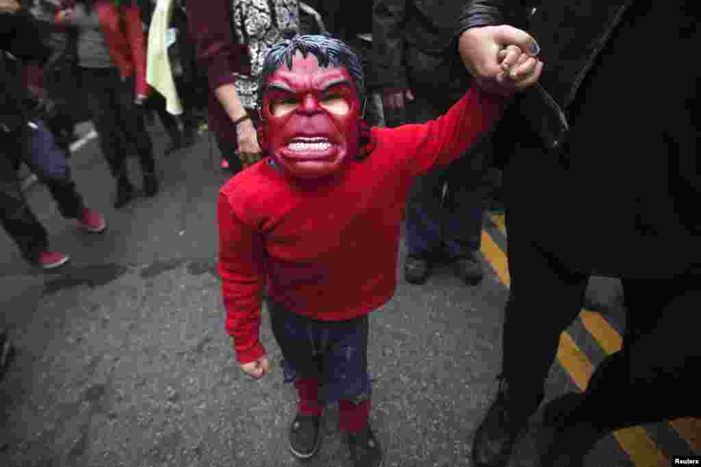 کودک نقاب پوش در حال انتظار برای حضور در یک برنامه ویژۀ هالووین در شهر نیویارک