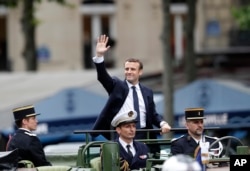 지난 5월 취임한 에마뉘엘 마크롱 프랑스 대통령이 취임식 후 파리 시내에서 열린 퍼레이드에서 환영 인파에 손을 흔들고 있다.