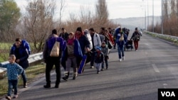 FILE - Migrants trudge toward a makeshift refugee camp in the northern Greek border station of Idomeni, where they hope to get permission to move onto other points in Europe, March 4, 2016. (J. Dettmer/VOA) 