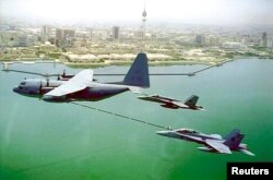 FILE - A U.S. Marine Corps KC-130 refuels two F/A-18 fighter planes as they soar high above Kuwait, Dec. 22, 2000. The KC-130 is a Marine Corps aircraft. It is a refueling version of the C-130 military cargo plane and can also be used to carry passengers.
