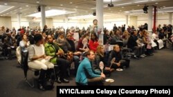 Members of the New York Immigration Coalition watch President Barack Obama's televised speech about his executive order Thursday evening.