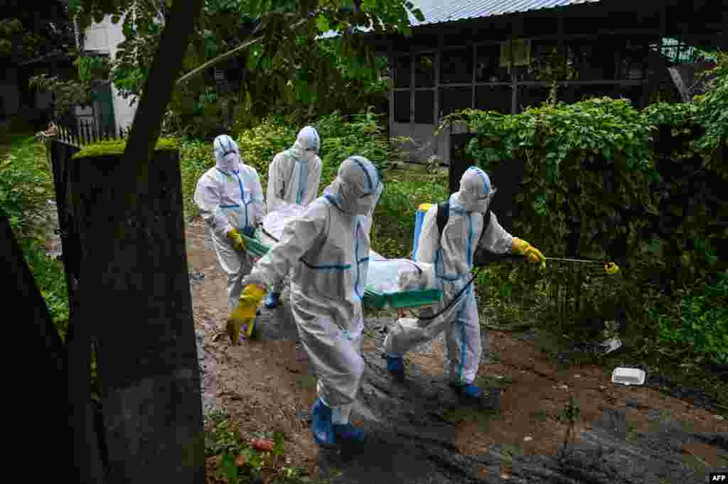 Volunteers wearing personal protective equipment&nbsp; carry the body of a victim of the Covid-19 to a cemetery in Hlegu Township in Yangon, Myanmar, July 10, 2021.