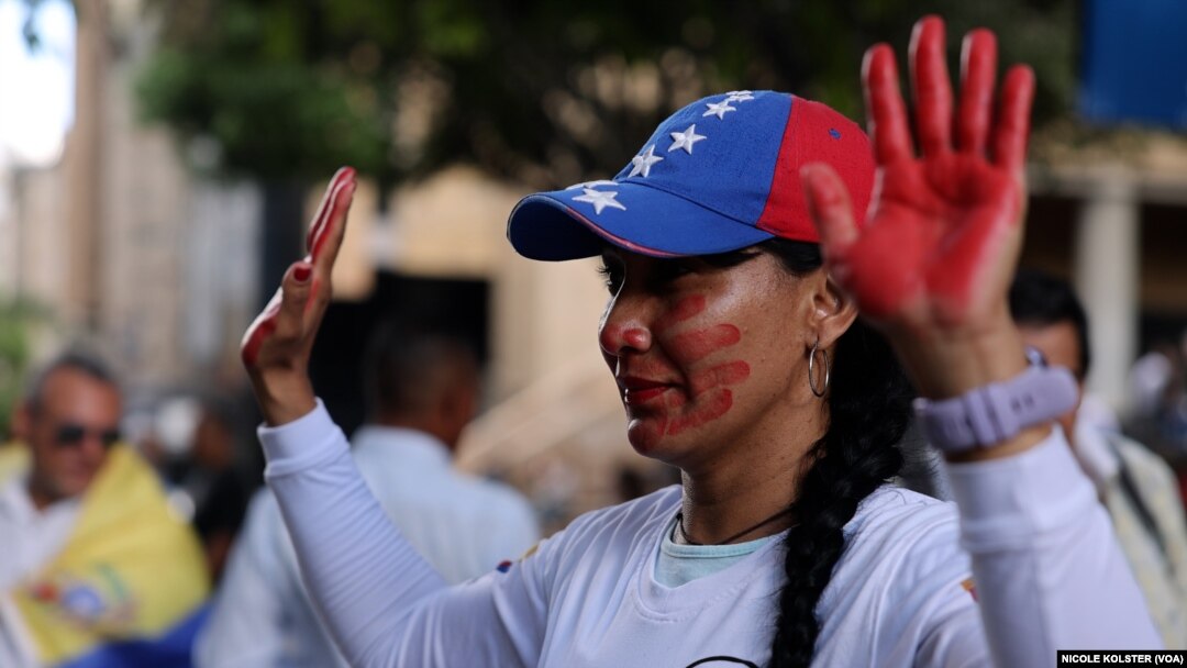 Una mujer con rostro y manos pintadas de rojo en señal de rechazo a la represión gubernamental, durante un acto celebrado el domingo 1 de diciembre de 2024 en Caracas, Venezuela. 