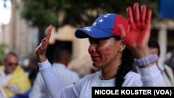 Una mujer con rostro y manos pintadas de rojo en señal de rechazo a la represión gubernamental, durante un acto celebrado el domingo 1 de diciembre de 2024 en Caracas, Venezuela. 