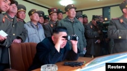 Picture released by North Korea's official KCNA news agency in Pyongyang Mar. 14, 2013 shows North Korean leader Kim Jong-un (C) and military officers watching a live shell firing drill to examine war fighting capabilities of artillery sub-units, whose mission is to strike DaeYeonpyeong island and Baengnyeong island of South Korea.