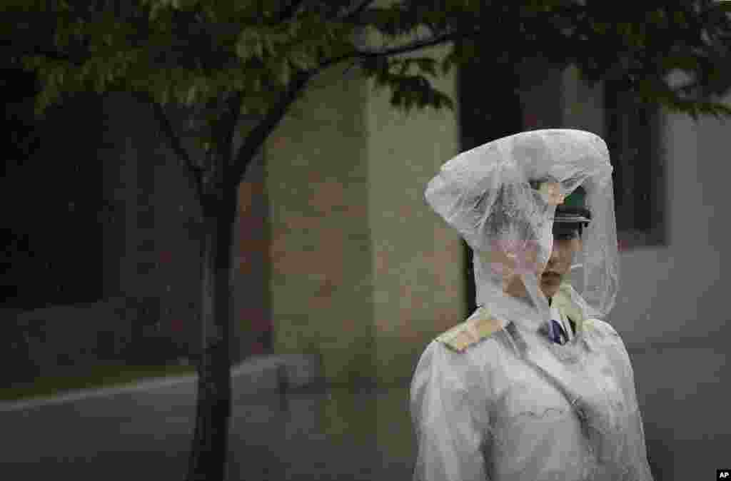 지난 7월 25일 평양에서 비를 맞으며 서있는 교통안내원.