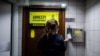 A woman is seen at the entrance to Amnesty International offices in Hong Kong as the Human Rights organization announces it will be closing its offices by the end of 2021.