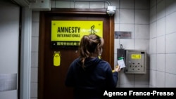 A woman is seen at the entrance to Amnesty International offices in Hong Kong as the Human Rights organization announces it will be closing its offices by the end of 2021.