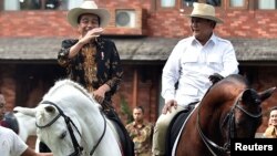 Presiden Joko Widodo (kiri) dan Ketum Gerindra Prabowo Subianto berkuda bersama di kediaman Prabowo di Hambalang, Bogor, 31 Oktober 2016.