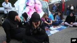 FILE - Families of Lebanese soldiers who were kidnapped by Islamic militants, block a main road during a protest after an al-Qaida-linked group in Syria says it has killed a kidnapped soldier Ali Bazzal, seen in poster with his daughter, in downtown Beirut, Lebanon on Dec. 6, 2014.