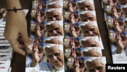 Una mujer ordena discos de música religiosa de Benedicto XVI. En el Líbano ha habido preparativos para la llegada del Papa.