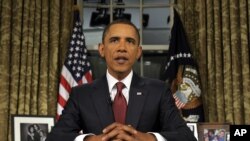 FILE - President Barack Obama reads his speech to photographers after delivering a primetime televised address from the Oval Office of the White House in Washington, Aug. 31, 2010.