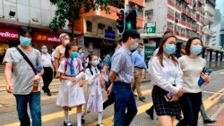 Para pejalan kaki mengenakan masker saat berjalan-jalan di Hong Kong, di tengah pandemi COVID-19, Senin 26 April 2021. (AP Photo/Vincent Yu)