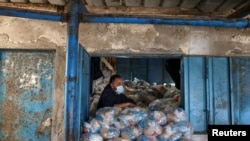 A Palestinian worker looks on as he prepares bags of food supplies at an aid distribution center run by United Nations Relief and Works Agency (UNRWA), at Beach refugee camp in Gaza City.