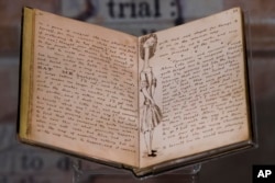 The illustrated original manuscript for Lewis Carroll’s Alice’s Adventures in Wonderland is displayed at the Rosenbach of the Free Library of Philadelphia Tuesday, Oct. 13, 2015, in Philadelphia. (AP Photo/Matt Rourke)