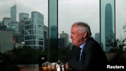 FILE - Former Hong Kong Governor Chris Patten sits in a hotel restaurant overlooking Hong Kong's financial Central district during an interview by Reuters in Hong Kong, March 15, 2012. 