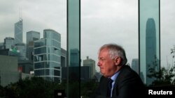 FILE - Former Hong Kong Governor Chris Patten sits in a hotel restaurant overlooking Hong Kong's financial Central district during an interview by Reuters in Hong Kong, March 15, 2012. 