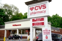 FILE: Vehicles are parked in front of a CVS Pharmacy in Mount Lebanon, Pa., on May 3, 2021.